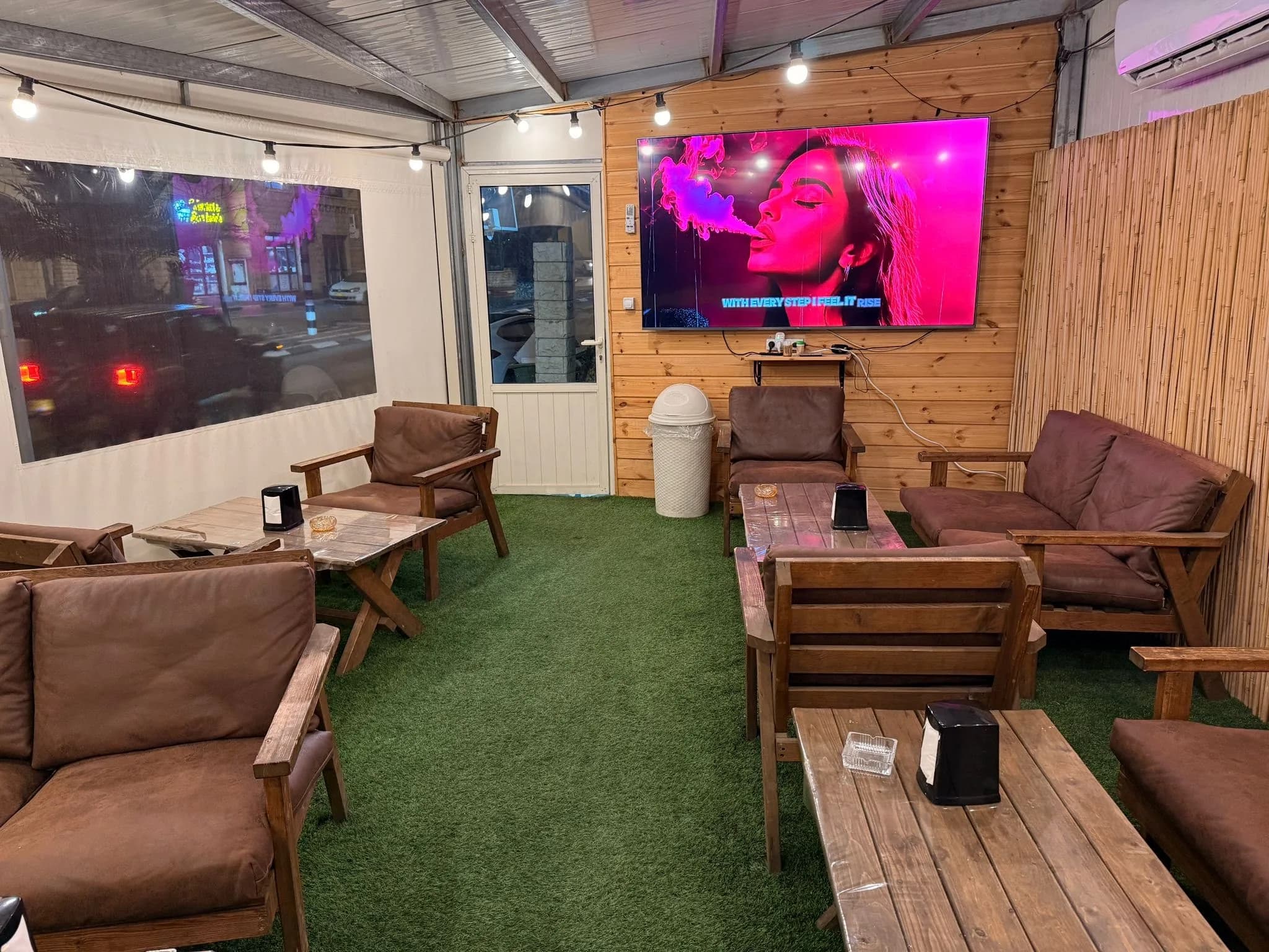 Cozy indoor seating area with TV and wooden decor at 2Eat Restaurant