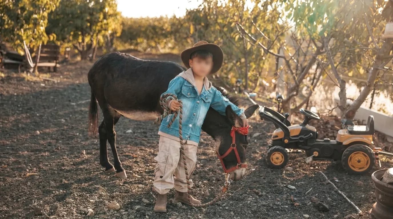 Child standing beside a donkey in an orchard