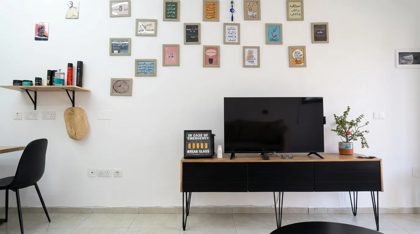 Waiting area inside a barber shop with a television and framed wall decorations