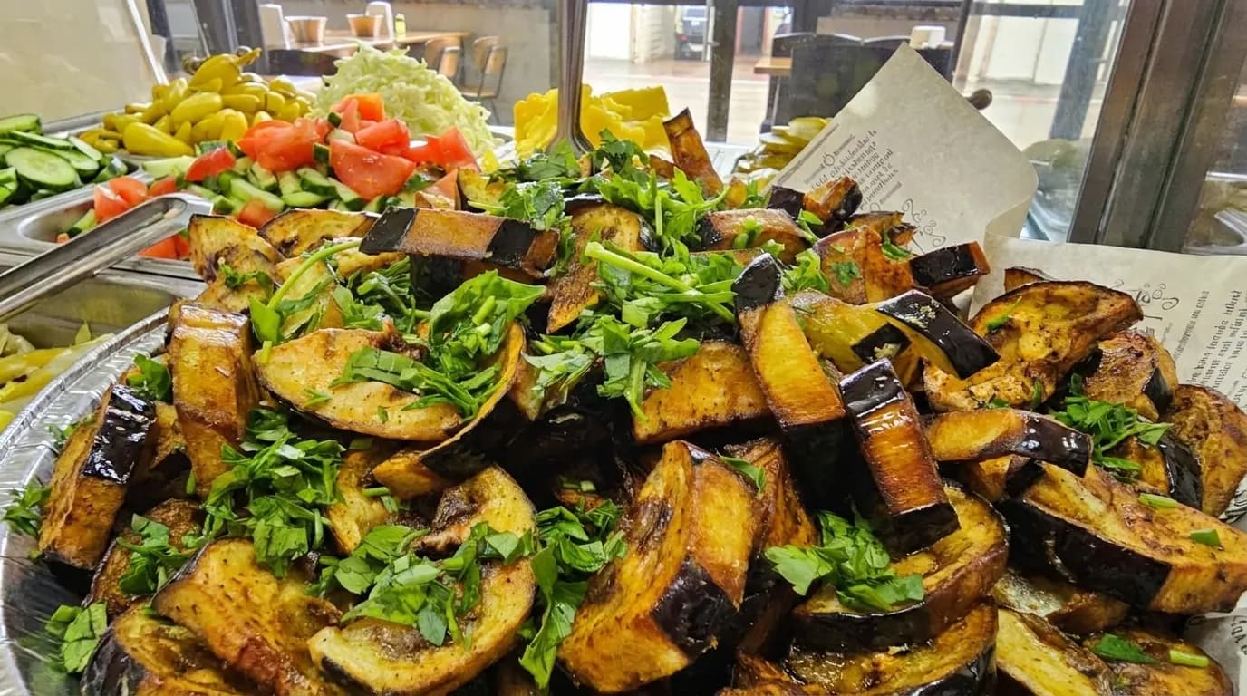 Fried eggplant slices topped with herbs at Falafel HaGolan