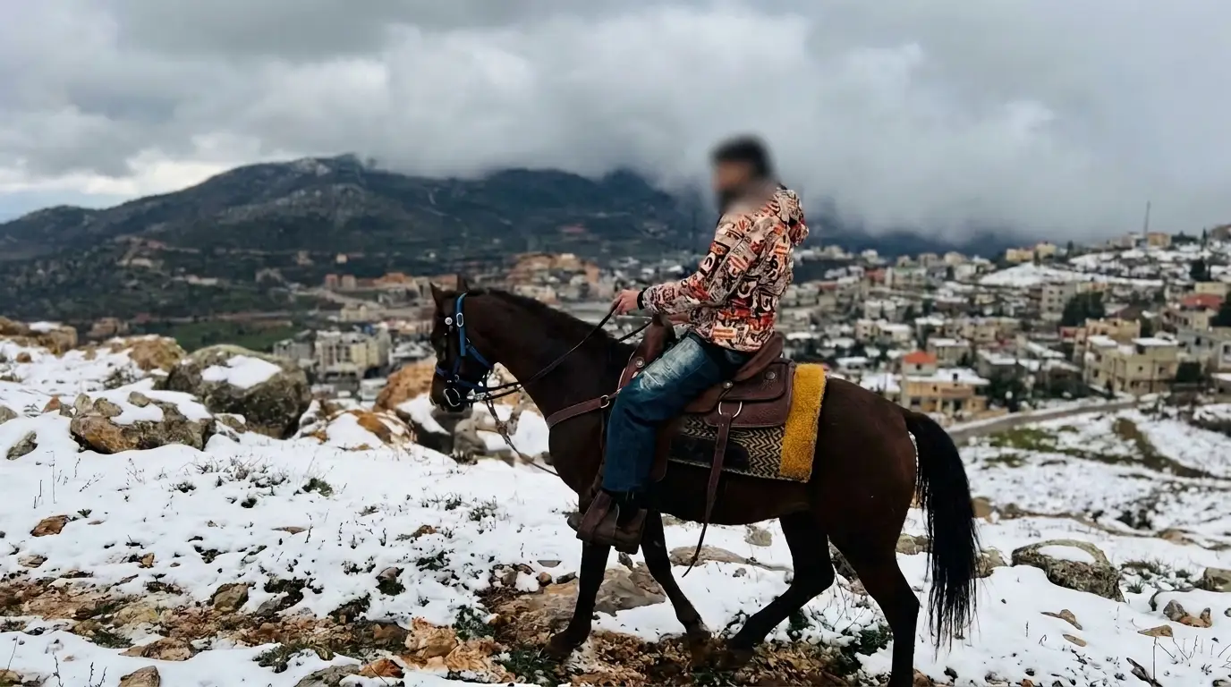Horseback rider in snowy mountain conditions with Al Ajeed Horse Farm