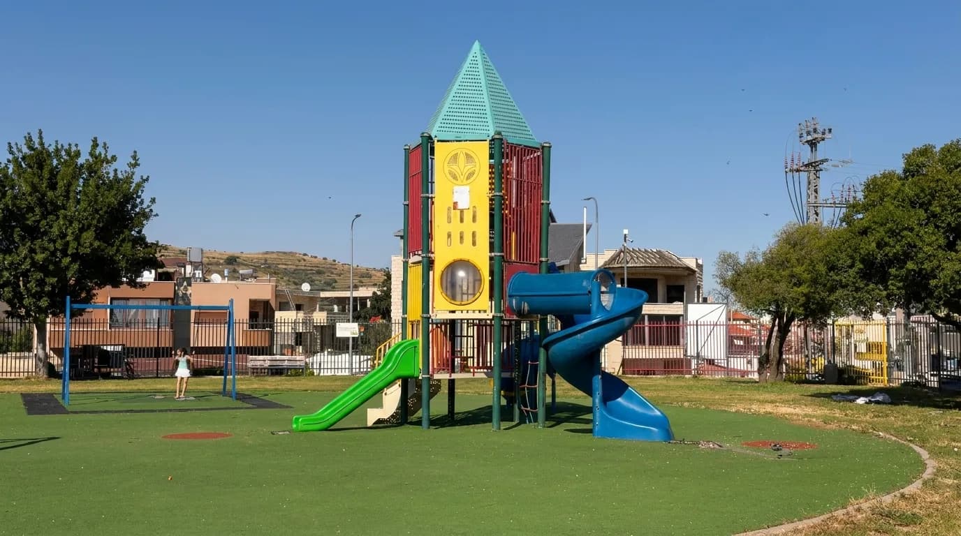 מגדל משחקים גבוה עם מגלשות ירוקות וכחולות בפארק בוקעאתא